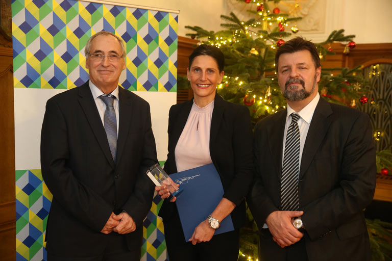 Der IHK Vizepräsident Hans-Joachim Münch und der Hauptgeschäftsführer der IHK Halle-Dessau, Prof. Dr. Thomas Brockmeier, überreichten im Rahmen einer Festveranstaltung die Siegertrophäen und Ehrenurkunden an die Abteilungsleiterin für Ausbildung Mandy Nickeleit. • © ADAC Dienstleistungs-Center GmbH